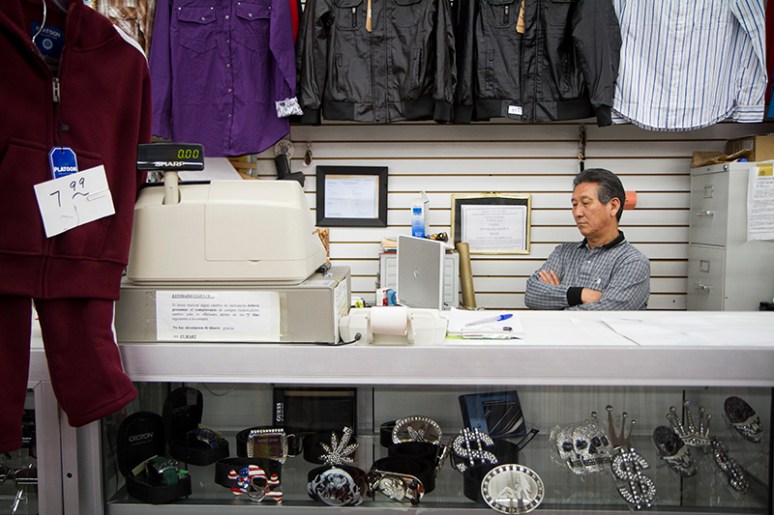 ﻿Man Ku Baek, a Korean business owner in downtown Nogale, Ariz., watches a Korean television show behind his cash register at Susan's Fashion. (Photo by Josh Morgan)